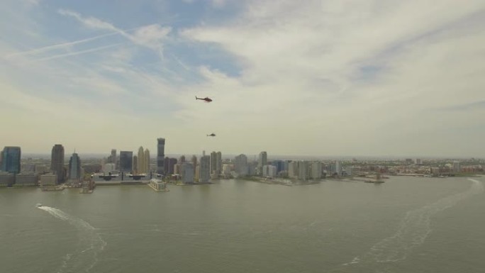 空中。两架直升机在纽约市哈德逊河上方的无人机附近飞行