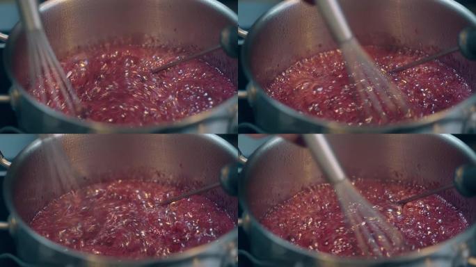 女人用小搅拌器搅拌煮沸的红莓焦糖
