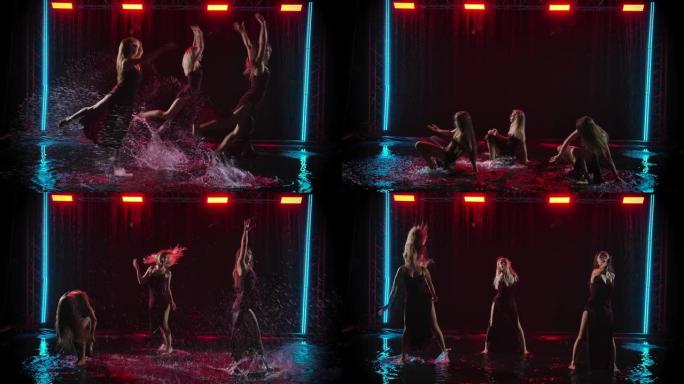 三位苗条的女舞者在落水的背景下优雅地在雨水坑中跳舞。慢动作
