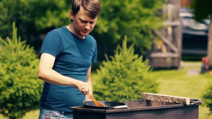 特写镜头，慢动作: 男人在大锅中，在煤上，在烤架上烹饪抓饭。搅拌肉。