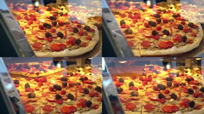美味的甜披萨搭配新鲜的覆盆子和黑莓，香蕉披萨在橱窗里出售。街头食品背景，蔬菜