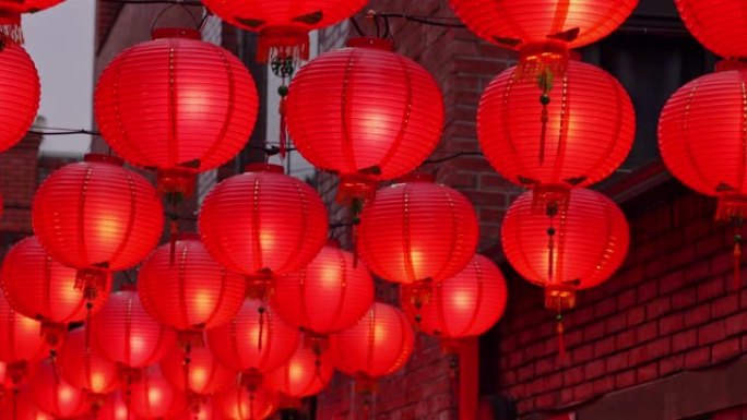 晚上走在中国传统街道上，美丽的圆形红灯笼悬挂着摇曳，是农历新年的概念。