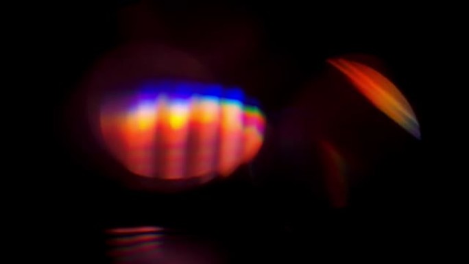 具有虹彩眩光的多面棱镜。多面钻石内部明亮的彩虹色反射。刻面产生光衍射和折射。在黑色背景上拍摄慢动作特