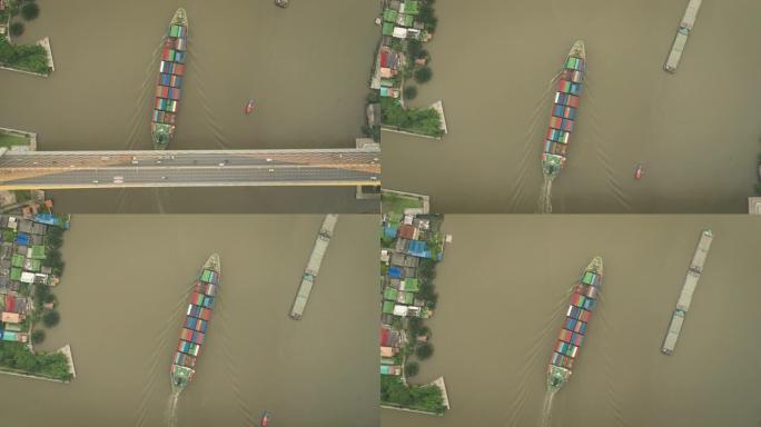 空中俯视集装箱货船承运人在河上进行物流，进出口，运输或货运。