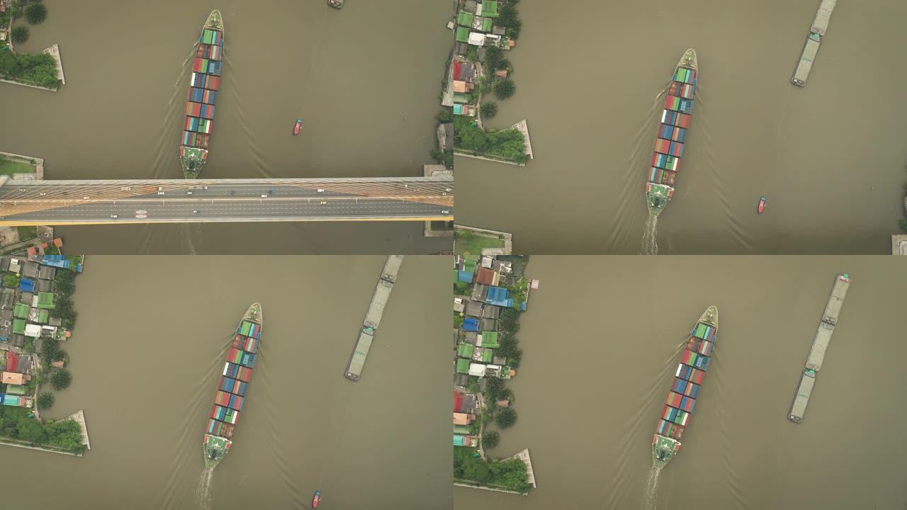 空中俯视集装箱货船承运人在河上进行物流，进出口，运输或货运。