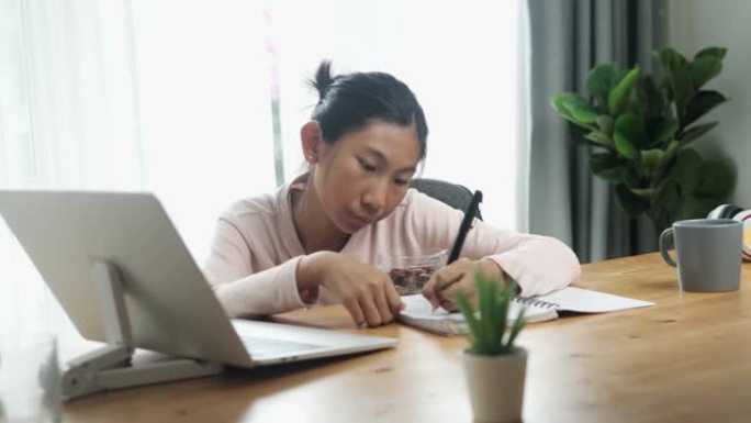 快乐的亚洲女孩在家吃点零食，生活方式理念。