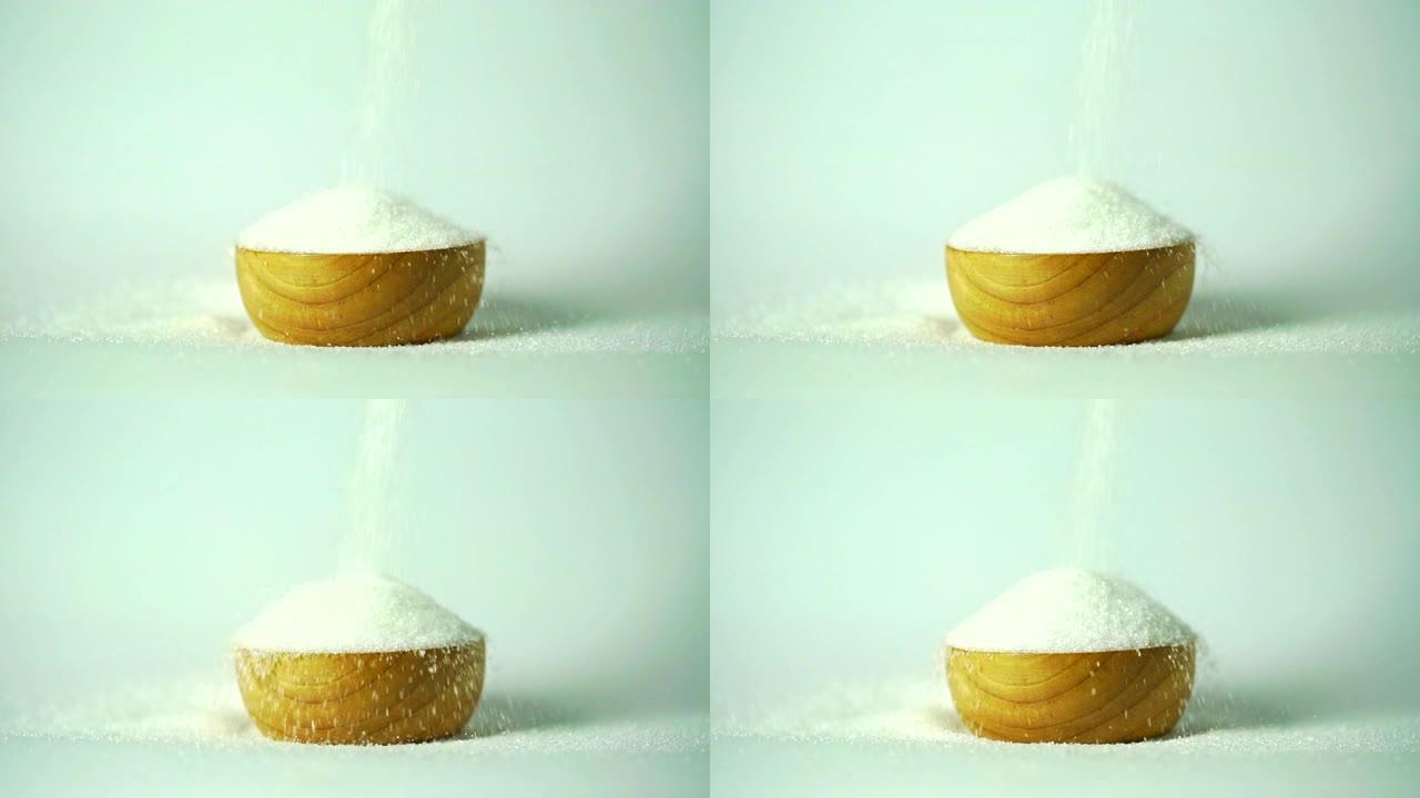 白色和灰色背景的木碗上的糖片段。