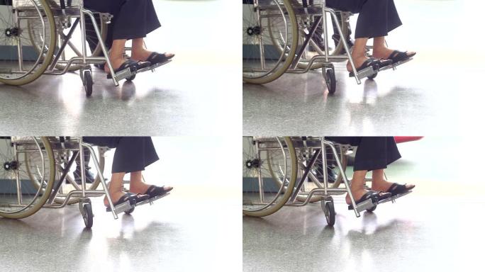 坐在轮椅上的病人的特写腿。