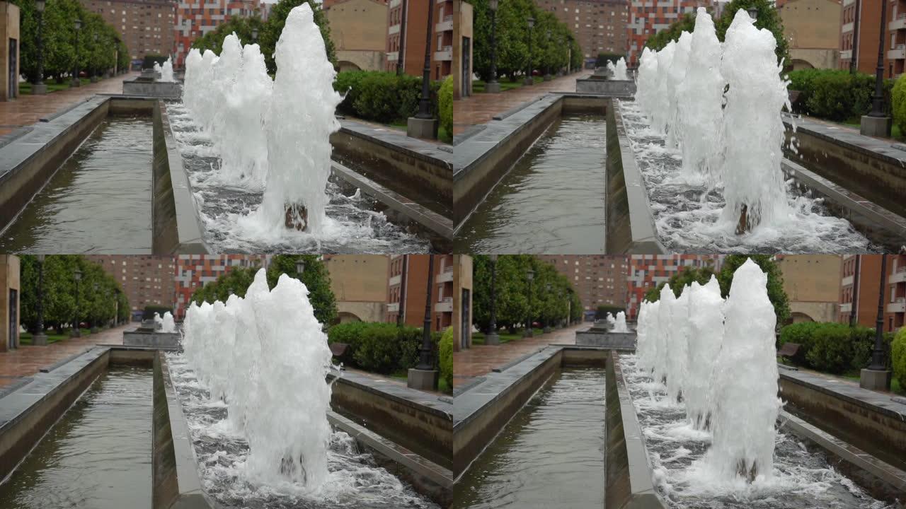 泡沫状的水流上升和下降。城市公园的喷泉小巷。