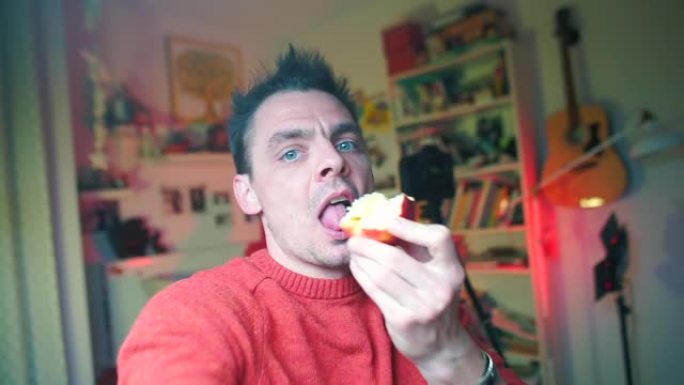 穿着红色衣服的Vlogger手里拿着相机，吃苹果。