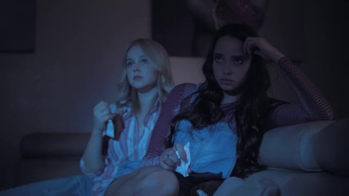 两个年轻美丽的悲伤女孩正在观看悲伤的情节剧