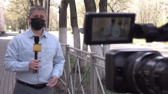 一名戴着防护医用口罩的欧洲中年记者正在一座荒芜的城市报道。