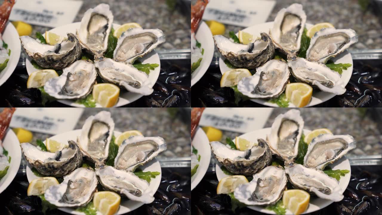 半壳上的新鲜牡蛎，盘子上有柠檬片，传统的鱼市场上有各种美味和新鲜的海鲜。昂贵的海洋美食概念