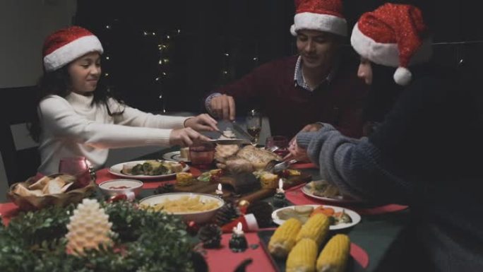 女儿在圣诞节之夜在餐厅与父亲和母亲一起吃晚餐