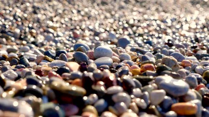 特写。圆石滩。地中海沿岸美丽的多色圆形鹅卵石。夏天阳光明媚的日子。希腊