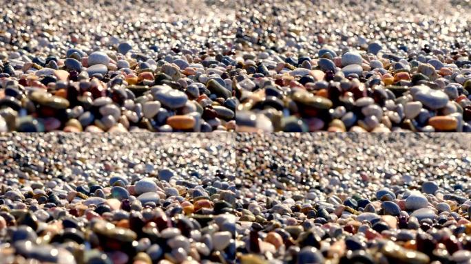 特写。圆石滩。地中海沿岸美丽的多色圆形鹅卵石。夏天阳光明媚的日子。希腊