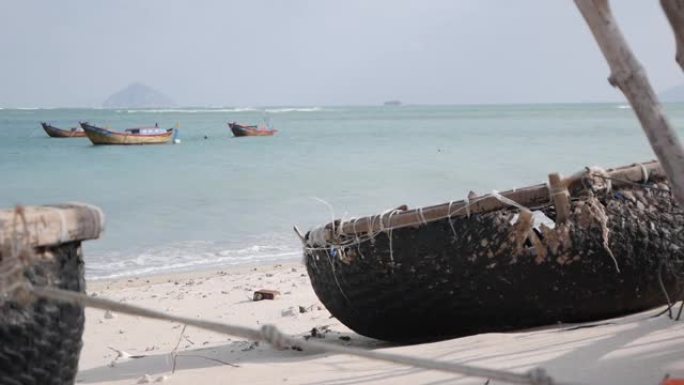 传统的越南圆船在海上背景渔村的沙滩上。渔船和文化象征