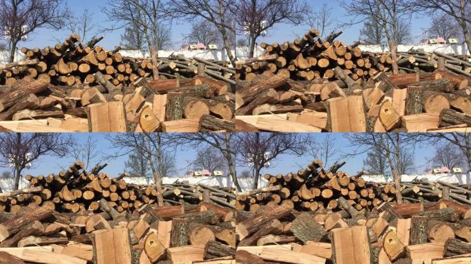 在阳光明媚的日子里，几根原木以慢动作飞入一堆切碎的柴火中