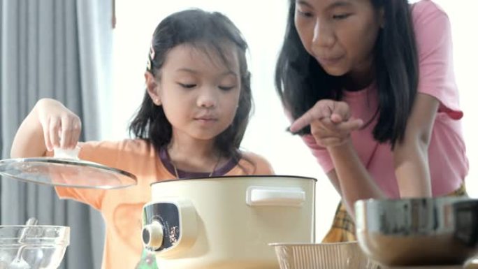 快乐的亚洲孩子在家里做饭时打开火锅。