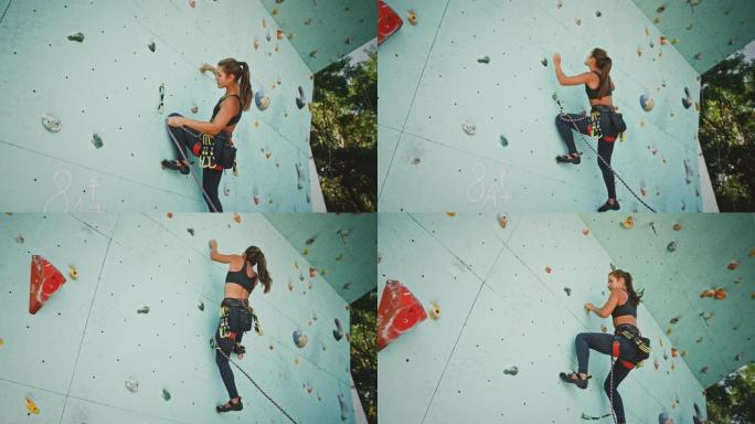 活跃的女人在攀岩馆的人造岩壁上练习攀岩，视图下方