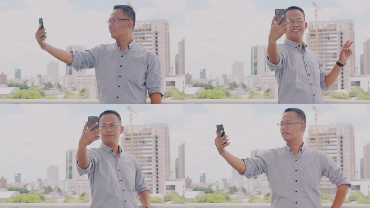 亚洲商人在视频会议中与合作伙伴交谈。男人在视频通话中使用电话或智能手机进行在线会议