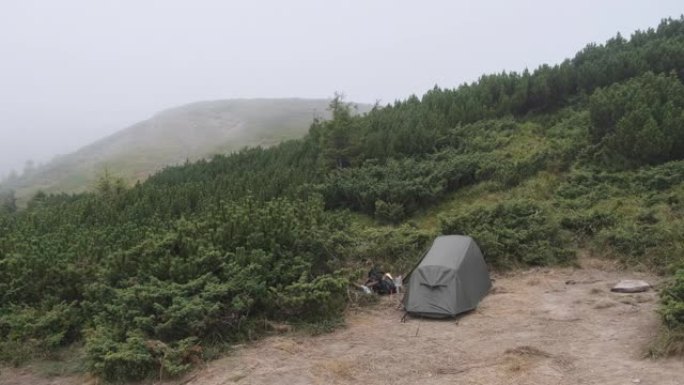 在恶劣大风天气下，在靠近山顶的小山上支起一个帐篷