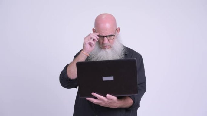 成熟的秃头大胡子男人使用笔记本电脑