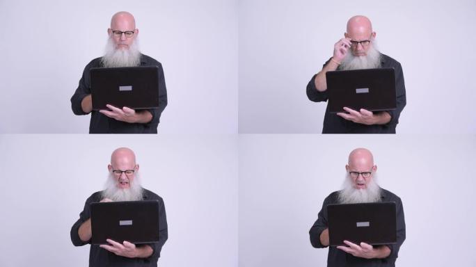 成熟的秃头大胡子男人使用笔记本电脑