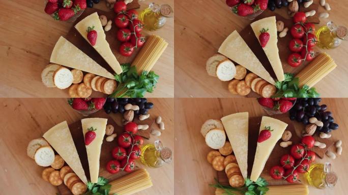 木制背景上的有机奶酪、水果、坚果奶酪拼盘。从上方观看。樱桃。美味的奶酪小吃。