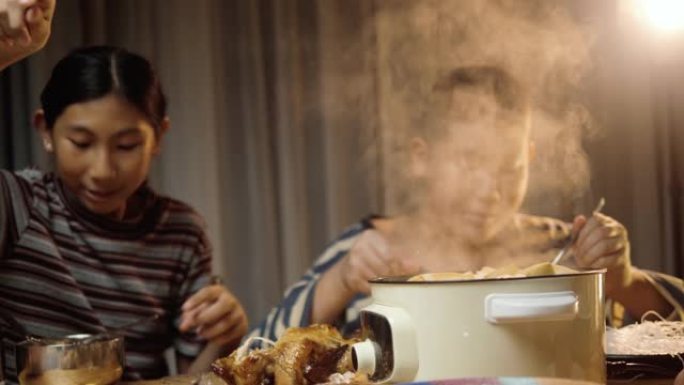 快乐的亚洲儿童晚上在家一起吃沙巴沙巴，生活方式理念。