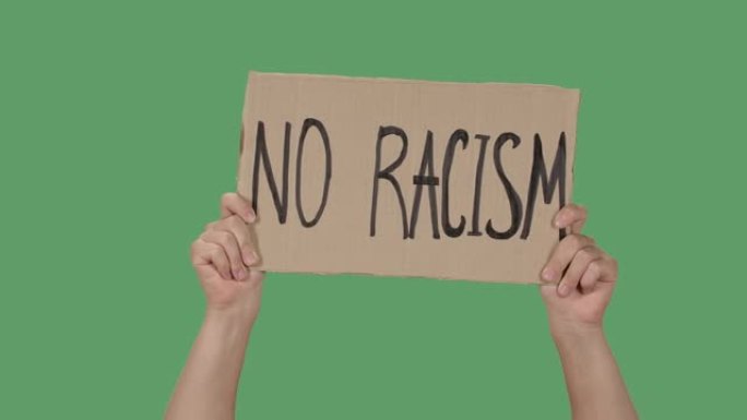 女性的手从纸板箱上拿着海报，上面写着 “没有种族主义”。抗议种族主义和警察暴行。隔离了一个绿色屏幕，