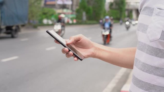 在街上使用手机的人的手。交通应用的使用
