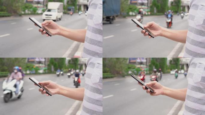在街上使用手机的人的手。交通应用的使用