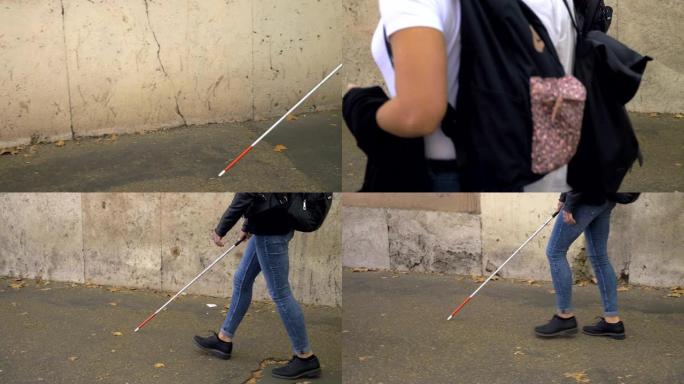 盲人用棍子独自走在街上。失明，独立