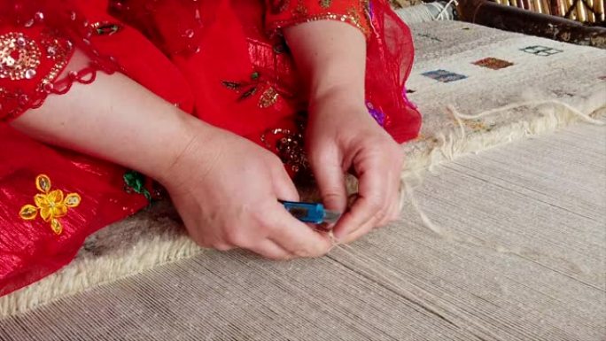 红色编织地毯特写慢动作的Qashqai女人