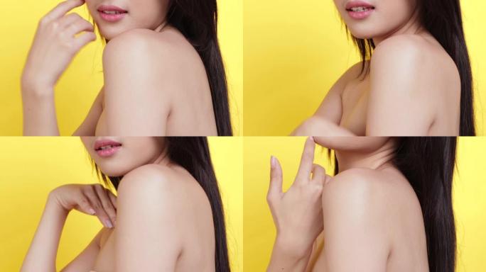 护肤概念。肖像摆亚洲美女手触摸脸和肩膀与黄色背景工作室拍摄。