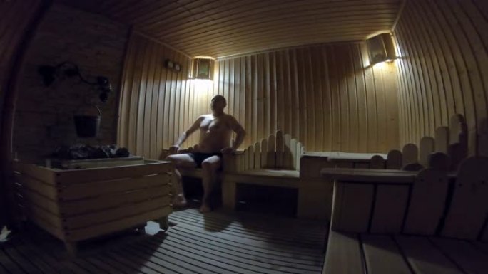 英俊的男人在桑拿浴室放松并保持健康