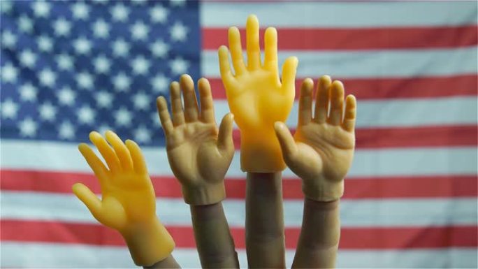 在美国国旗的背景下，木偶的手升起