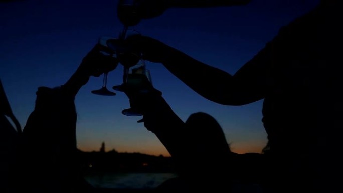 酒精。游艇上喝葡萄酒的人的剪影。