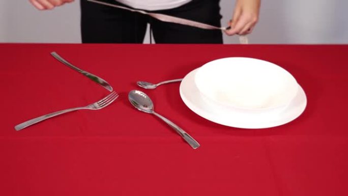 手把银餐具放在桌子上，用胶带测量