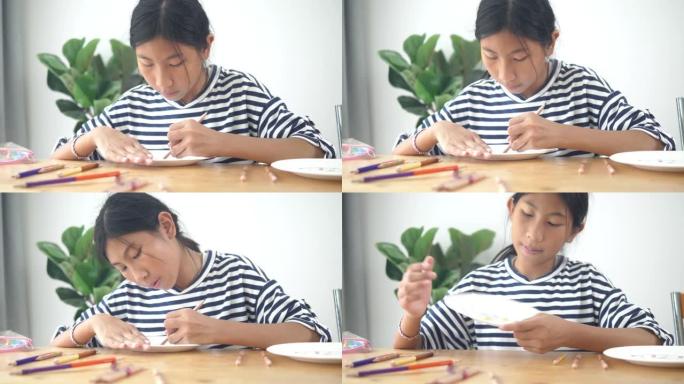 快乐的亚洲女孩在纸盘上画画，在家生活方式活动。