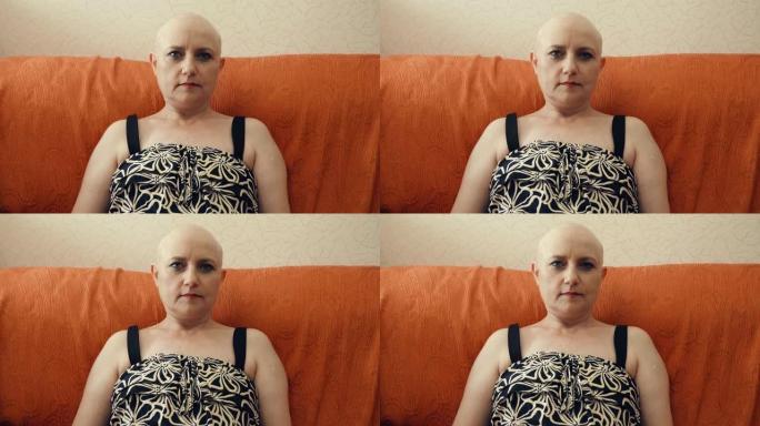 做化疗后的秃头女人坐在沙发上盯着相机