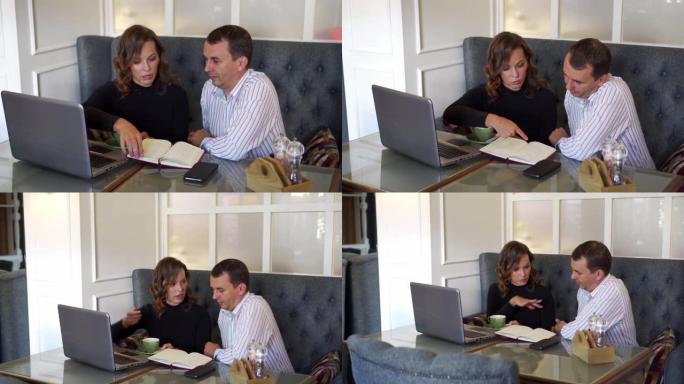 两个人，一男一女，正在一起讨论一项商业计划。他们坐在桌子旁，凝视着笔记本电脑的屏幕。不同性别的办公室