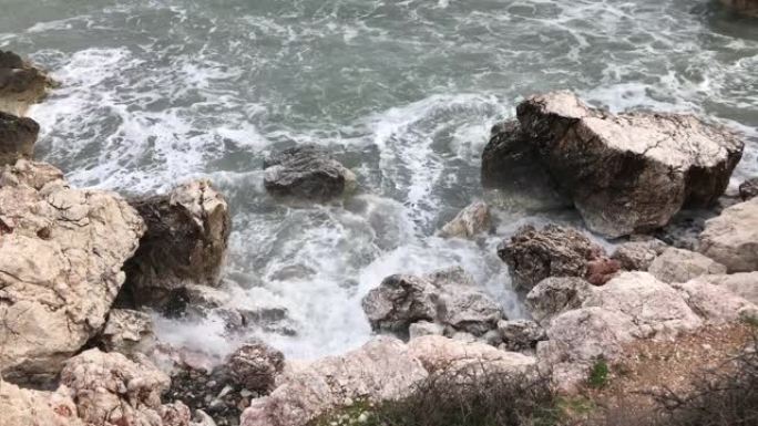 海浪拍打着岩石。晶莹剔透的大海，层层叠叠的岩石和美丽的大自然。蔚蓝的海滨。选择性聚焦