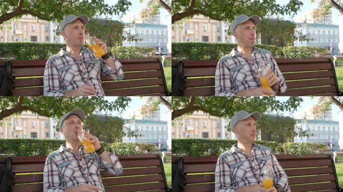 一个白人男子坐在公园的长凳上喝果汁四处张望