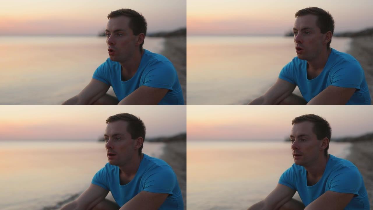 男子坐在沙滩上呼吸困难
