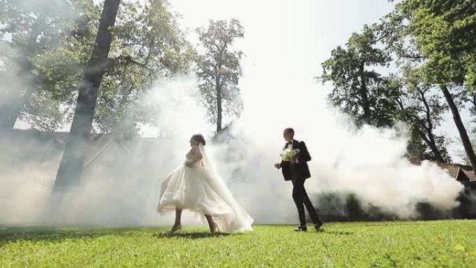 婚礼情侣在公园里一起跑步。可爱的新郎和新娘。幸福的家庭。恋爱中的男人和女人。婚礼当天。