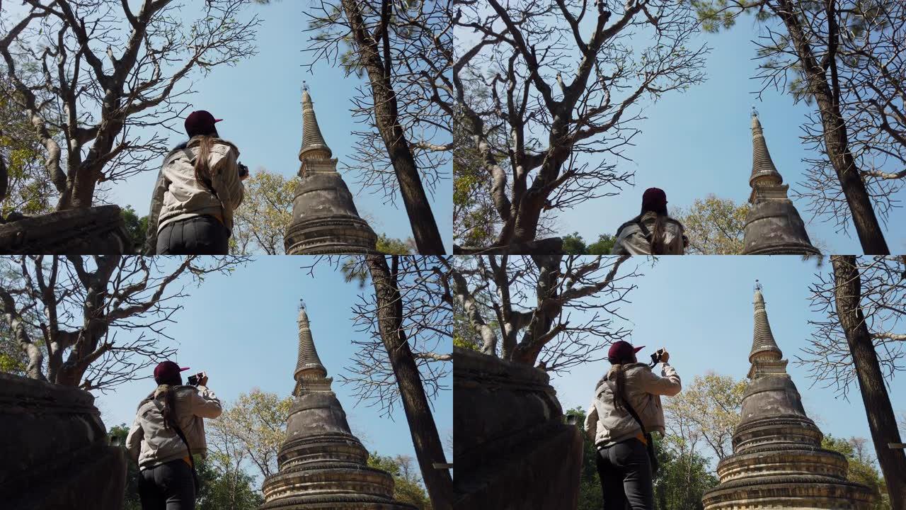 年轻女子在老庙和佛头雕像旅行