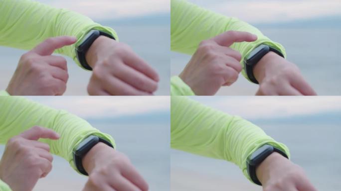 关闭亚洲健身女性在智能手表上手动设置健康跟踪，并在早上海滩慢跑时检查心率