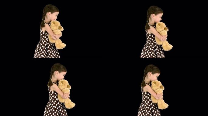 穿着圆点连衣裙的小女孩边走边看相机边拥抱大泰迪熊，阿尔法频道